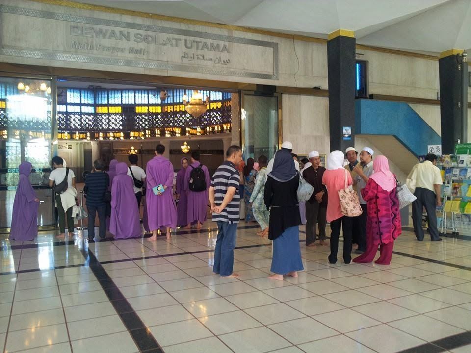 Pelancong berjubah ungu di hadapan Dewan Solat Utama Masjid Negara