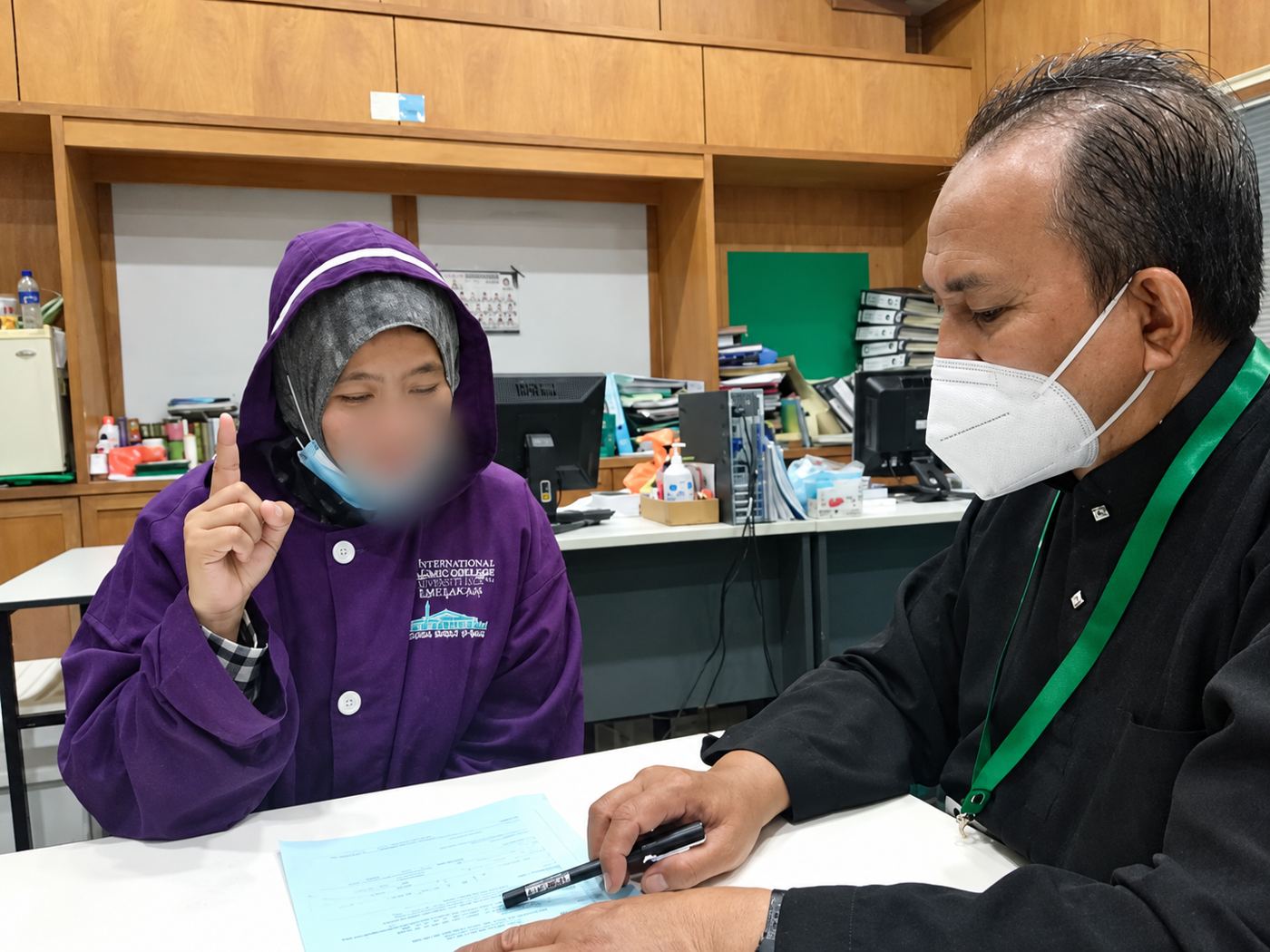 Saudara baharu mengangkat jari telunjuk ketika dibimbing oleh pegawai